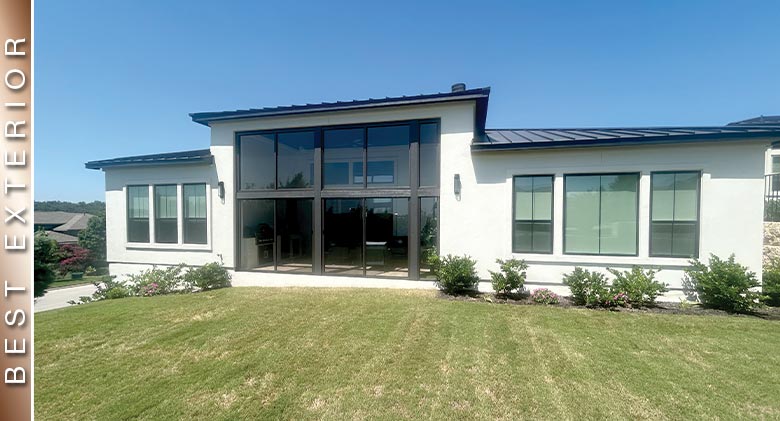 BEST EXTERIOR: Brown one-wall patio enclosure with extra-tall transom on white home with neat plantings in front.