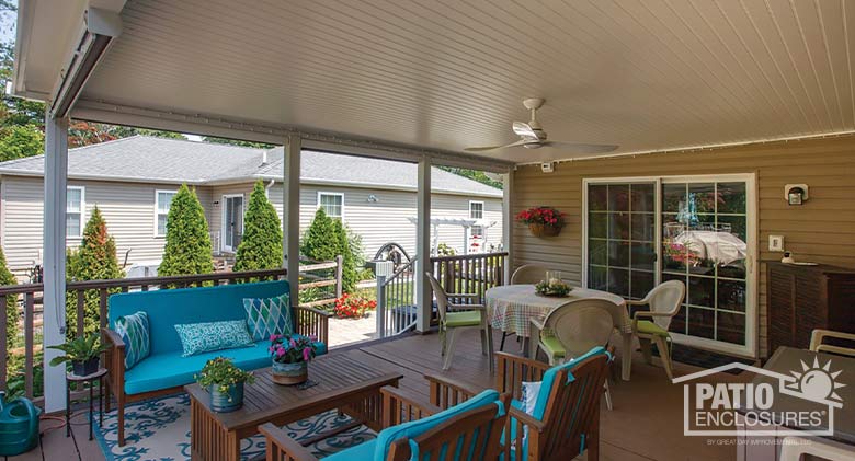 A large white deck cover over a comfortable conversation area and a dining table for four.