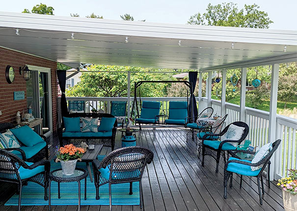 An enclosed patio showcasing a brick backyard wall, complemented by well-furnished seating areas in a pleasing blue hue.